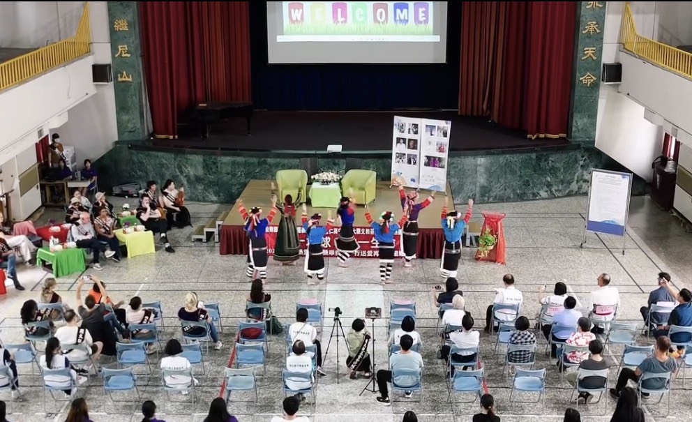 禮堂室內活動的高視角紀錄，呈現台前表演與觀眾席