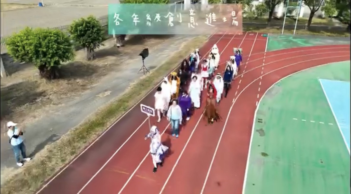 校園運動場高視角畫面，記錄各年級創意進場隊伍沿跑道行進